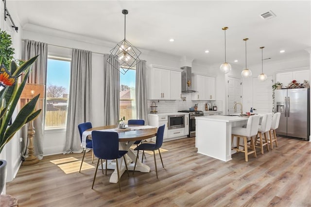 dining space with light wood-style flooring, recessed lighting, and visible vents