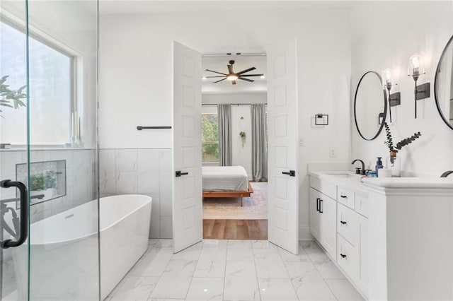 ensuite bathroom with vanity, a freestanding tub, ceiling fan, marble finish floor, and connected bathroom