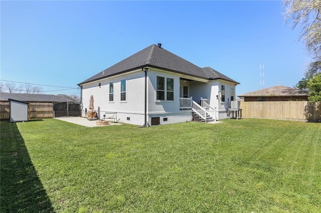 back of property with a yard, a fenced backyard, an outdoor structure, a storage unit, and crawl space