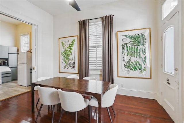 dining space featuring baseboards and wood finished floors