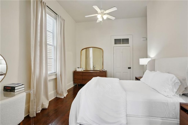 bedroom with dark wood finished floors, a ceiling fan, and baseboards