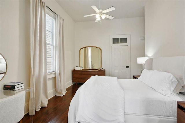 bedroom with ceiling fan, dark wood-type flooring, and baseboards