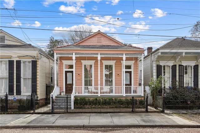 view of front of property featuring a fenced front yard, a porch, and a gate