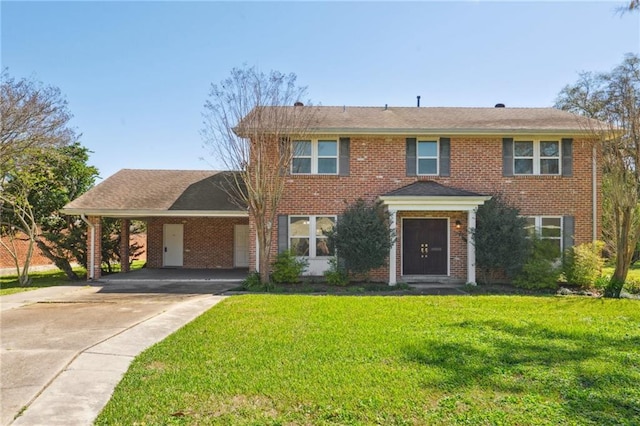 colonial home featuring an attached carport, brick siding, a front yard, and driveway