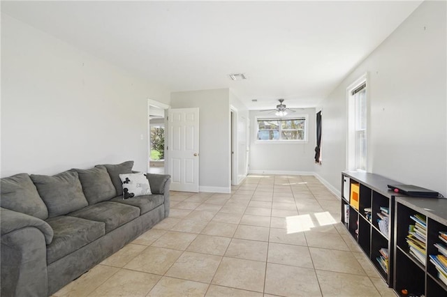 living area with light tile patterned flooring, visible vents, baseboards, and ceiling fan