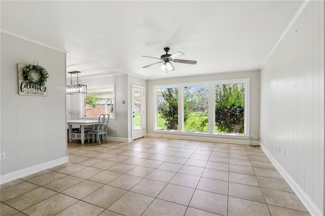 empty room featuring light tile patterned floors, a ceiling fan, baseboards, and ornamental molding