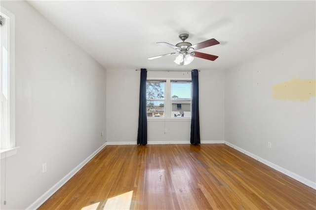 spare room featuring a ceiling fan, wood finished floors, and baseboards