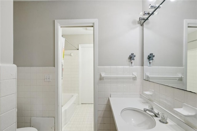 bathroom featuring vanity, tile walls, a wainscoted wall, and tile patterned floors