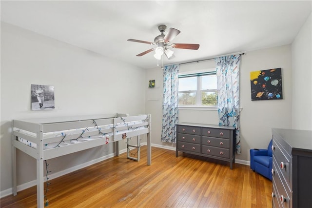 bedroom featuring ceiling fan, baseboards, and light wood-style flooring