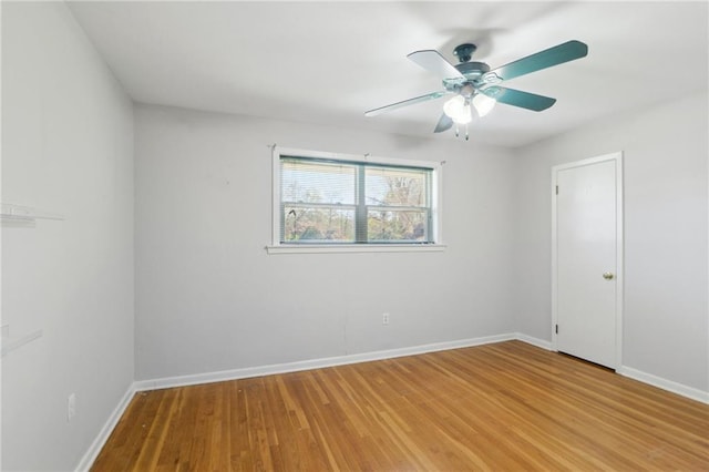 empty room featuring baseboards, light wood-type flooring, and ceiling fan