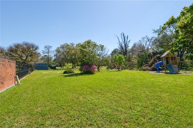 view of yard featuring fence and a playground