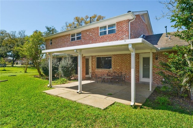 back of house featuring a yard, a patio area, and brick siding