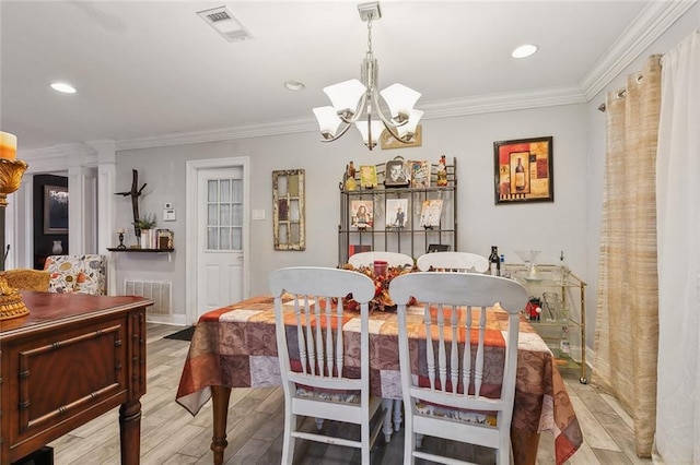 dining space with visible vents, light wood-style flooring, and crown molding