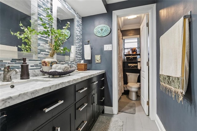 bathroom with toilet, vanity, baseboards, and ornamental molding