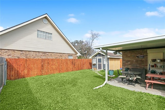 view of yard featuring an outdoor structure, fence, and a patio area