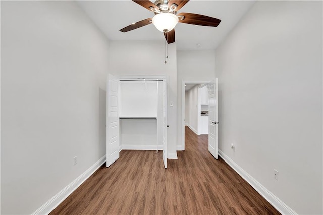 unfurnished bedroom featuring a ceiling fan, wood finished floors, baseboards, and a closet