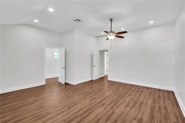 spare room featuring lofted ceiling, wood finished floors, and baseboards