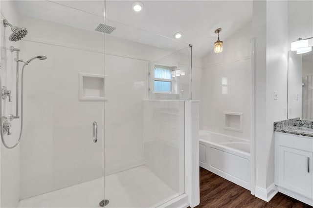 bathroom featuring vanity, lofted ceiling, wood finished floors, and a stall shower