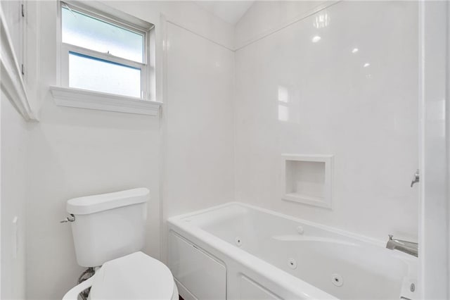 bathroom with toilet and a combined bath / shower with jetted tub