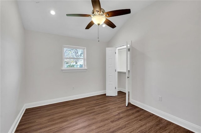 unfurnished bedroom featuring baseboards, wood finished floors, and vaulted ceiling