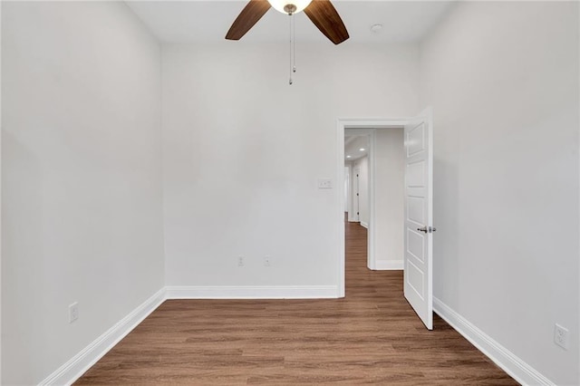 spare room featuring a ceiling fan, baseboards, and wood finished floors