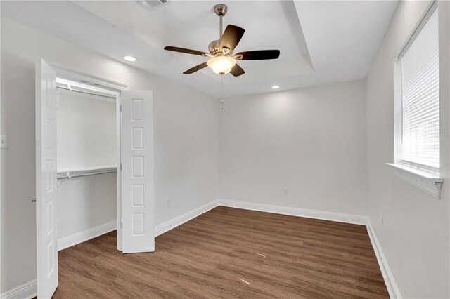 unfurnished bedroom with wood finished floors, recessed lighting, a closet, baseboards, and ceiling fan