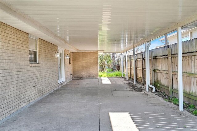 view of patio featuring an attached carport and fence