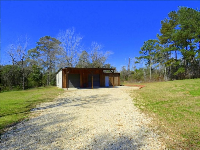 view of pole building featuring a lawn and driveway