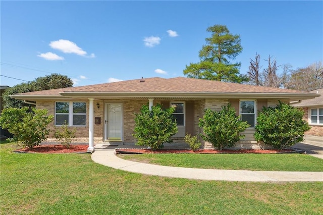 single story home featuring a front yard, brick siding, and roof with shingles