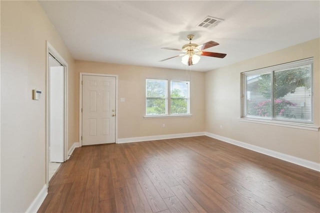 empty room with visible vents, baseboards, and wood finished floors