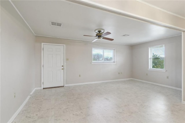 spare room featuring a wealth of natural light, visible vents, and baseboards