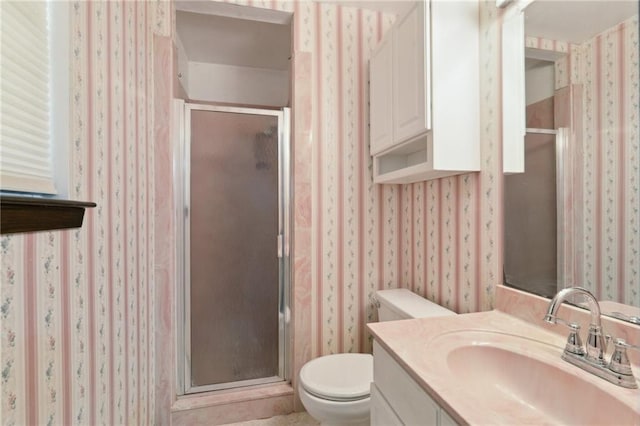 full bathroom featuring a shower stall, wallpapered walls, vanity, and toilet