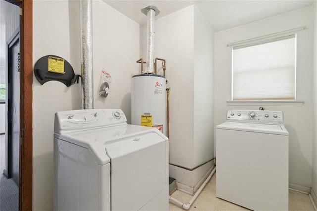 clothes washing area with washer and clothes dryer, water heater, and laundry area