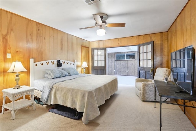 bedroom with a ceiling fan, wooden walls, carpet, and visible vents