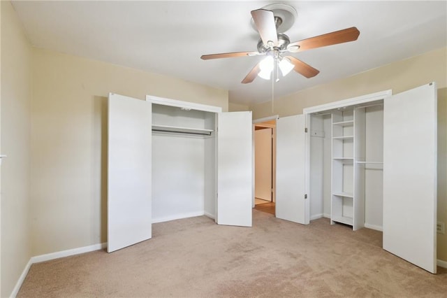 unfurnished bedroom with a ceiling fan, baseboards, two closets, and carpet floors