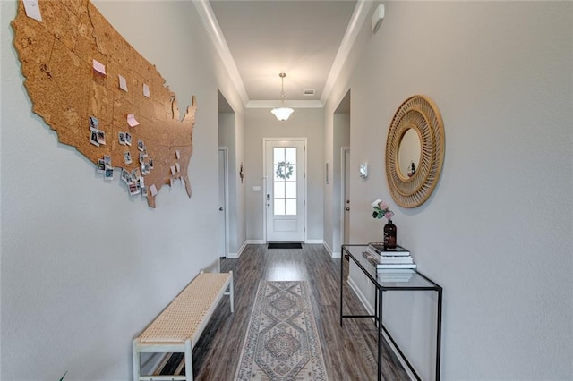 entryway featuring visible vents, crown molding, baseboards, and wood finished floors