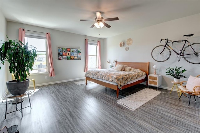 bedroom featuring wood finished floors, baseboards, and ceiling fan