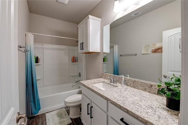 bathroom featuring visible vents, toilet, wood finished floors, shower / bath combination with curtain, and vanity