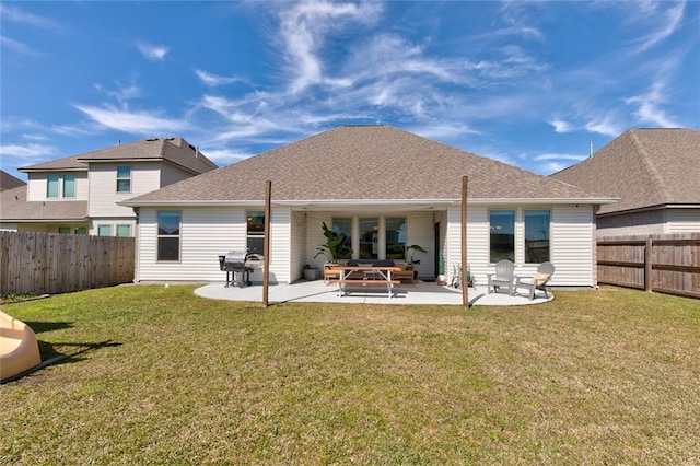 rear view of property with a patio area, a lawn, a fenced backyard, and roof with shingles