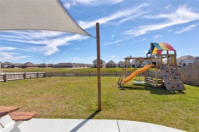 view of yard with playground community, a residential view, and a fenced backyard