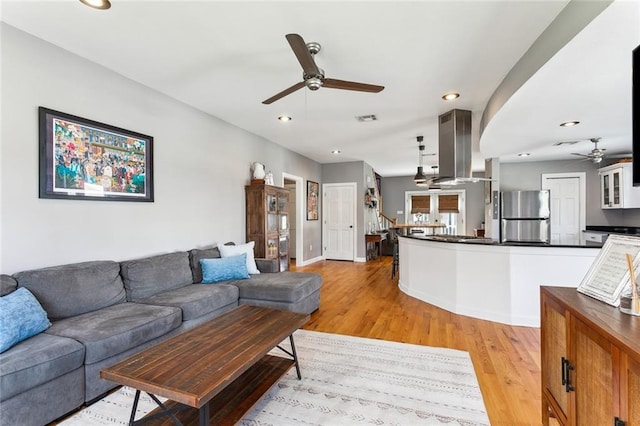 living area featuring visible vents, recessed lighting, ceiling fan, stairs, and light wood-style floors