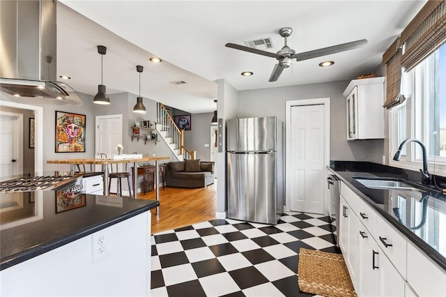 kitchen featuring visible vents, a sink, appliances with stainless steel finishes, dark countertops, and dark floors