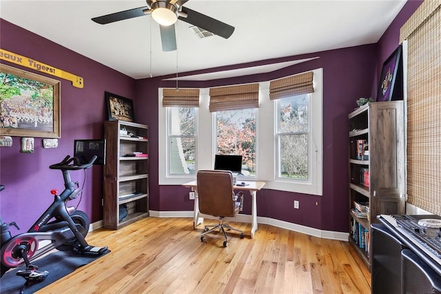 office space with light wood-type flooring, visible vents, baseboards, and a ceiling fan