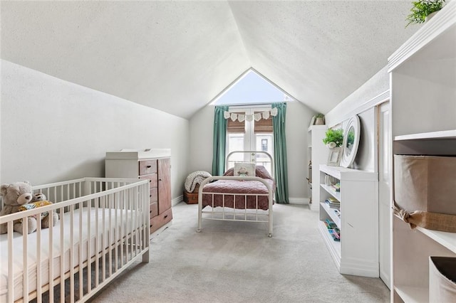 bedroom featuring carpet flooring, a textured ceiling, baseboards, and vaulted ceiling