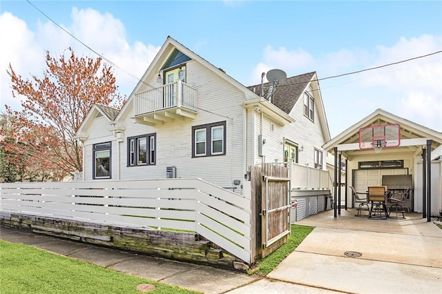 view of front of property with a balcony, a gate, a garage, and a fenced front yard