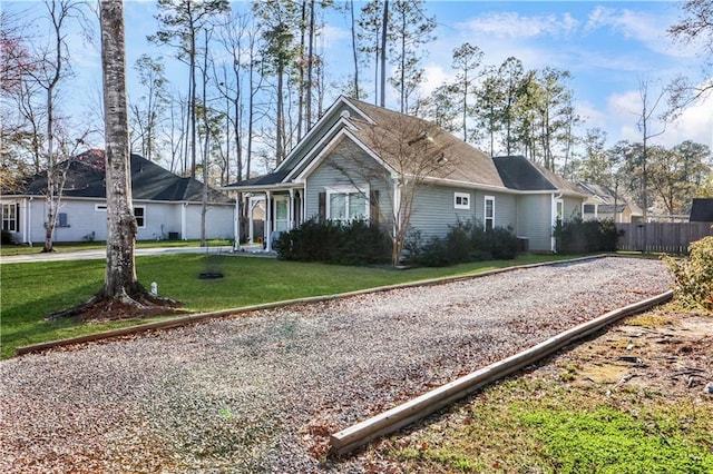 view of front of house with driveway, a front lawn, and fence