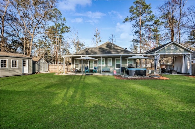 rear view of house with a hot tub, a shed, a gazebo, an outdoor structure, and a patio area