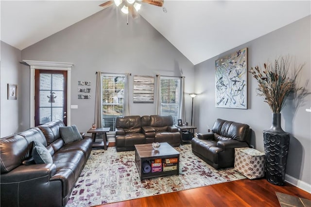 living area with high vaulted ceiling, a ceiling fan, and wood finished floors