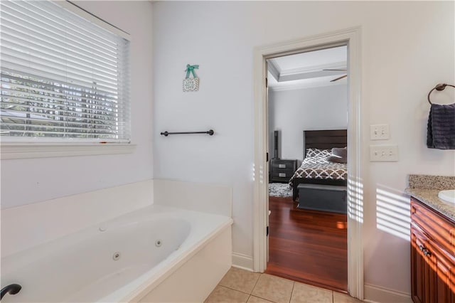 ensuite bathroom with tile patterned flooring, a jetted tub, vanity, and ensuite bathroom