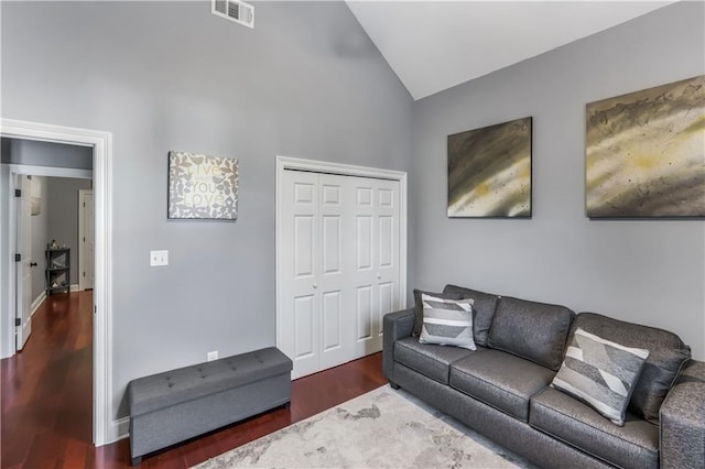 living area with visible vents, lofted ceiling, and wood finished floors